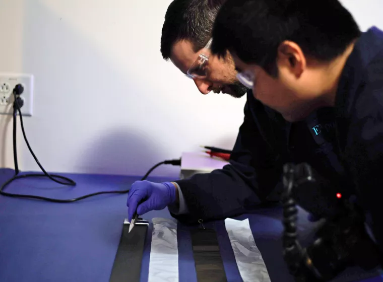 Two engineers test batteries in our Natick lab. Exponent provides independent, objective battery vendor analysis services.