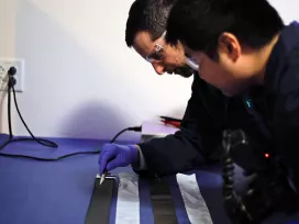 Two engineers test batteries in our Natick lab. Exponent provides independent, objective battery vendor analysis services.