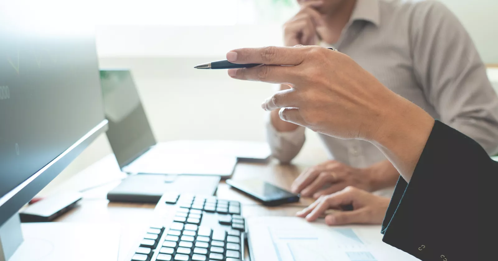Collegues at a computer. Exponent biomedical experts consult on medical products and regulatory compliance.