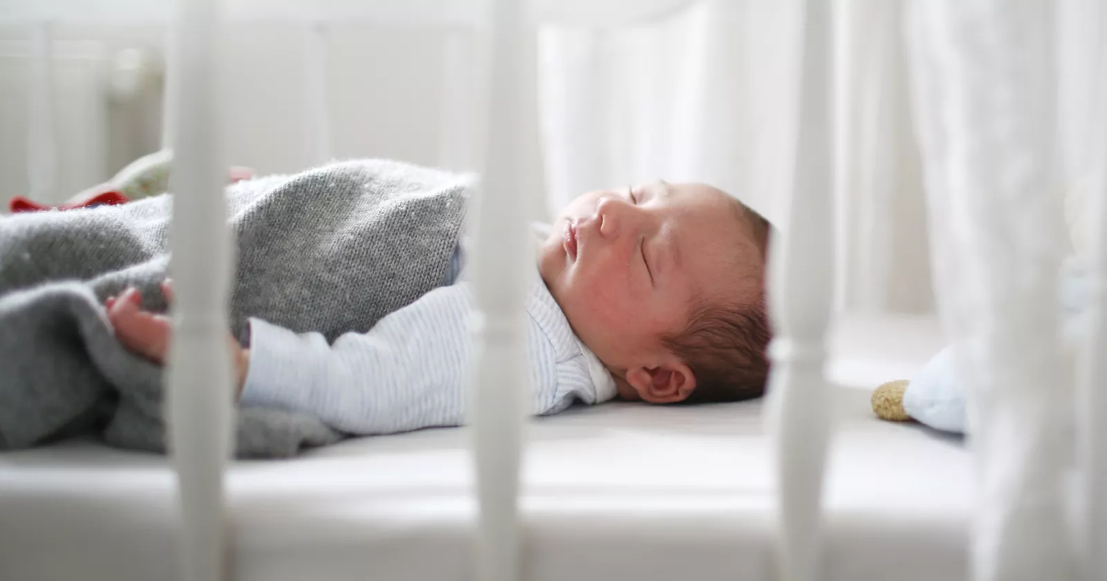 A baby sleeping peacefully in a crib. Exponent studies human factors to advance the safety and compliance of children's products.