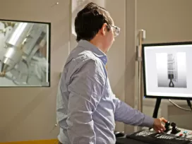 A scientist analyzes images of batteries on two computer screens. Exponent engineers help improve the safety and performance of batteries. 