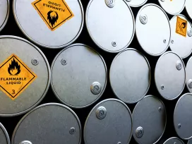 Stacks of steel barrels labeled with flammable liquid warning signs. Exponent helps improve safety of hazardous chemicals.