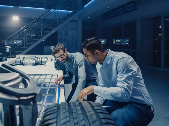 Two Automotive Engineers Working on Electric Car Chassis Platform
