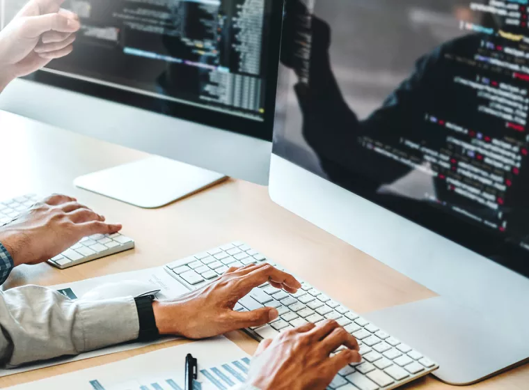 Hands typing on a keyboard while analyzing data on a computer screen. Exponent helps enhance the platforms and systems that drive business.