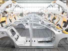 A side view of car frames on a robotic assembly line. Exponent provides support for all vehicle engineering challenges. 
