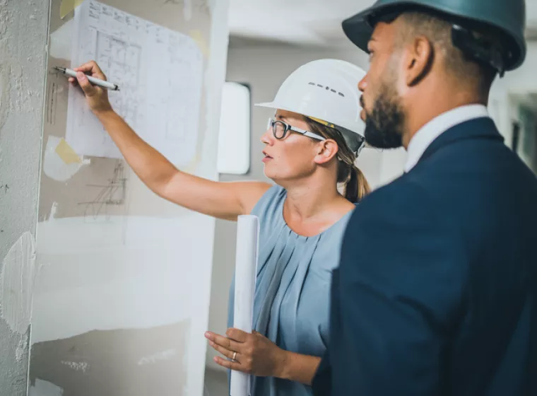 Construction professional at a site meeting. Exponent experts provide support for enterprise construction projects.