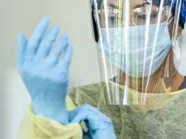 A healthcare worker wears personal protection gear. Exponent helps you improve workplace health and safety with health risk assessments.   