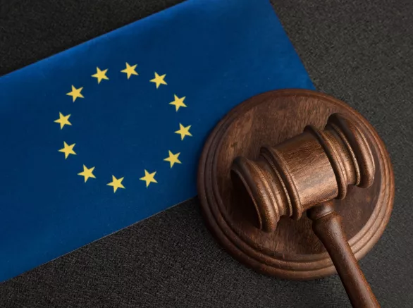 The European flag laid flat next to a gavel