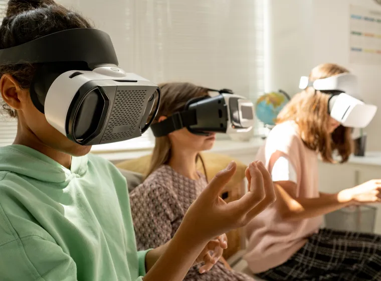 Schoolgirls in goggles holding invisible virtual objects