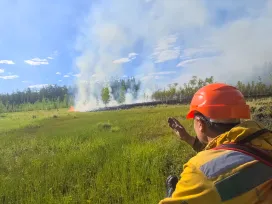 Firefighter shows his hand the direction of movement to the fire