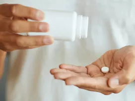 A person dispenses medicine from a bottle. Exponent helps improve the safety and efficacy of pharmaceutical products. 