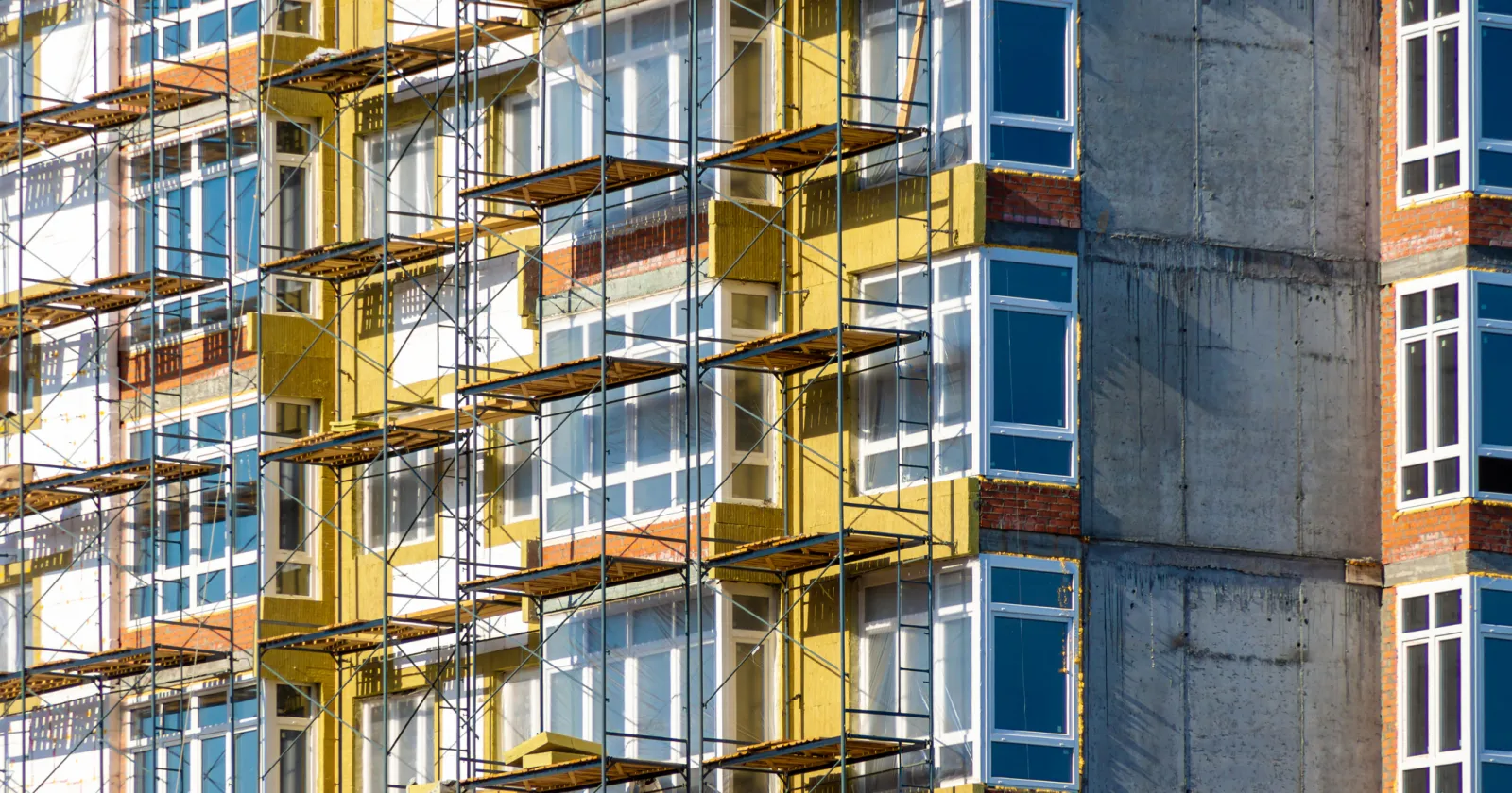 construction work at height during facade insulation from scaffolding or staging, selective focus