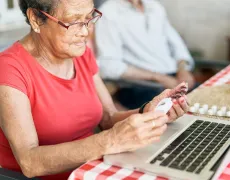 Patient looking over their prescriptions while sitting in front of a laptop