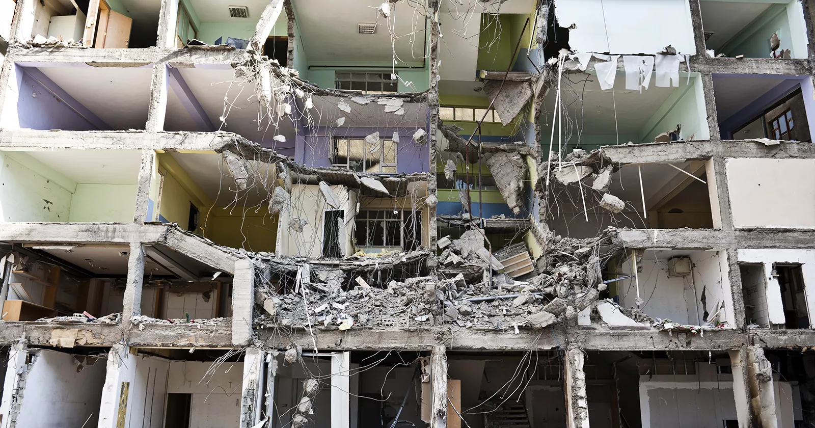 A collapsed apartment in the aftermath of an earthquake, rooms are exposed to the outside. Exponent experts assess the damage.