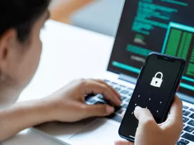 Woman using mobile phone and laptop computer at home