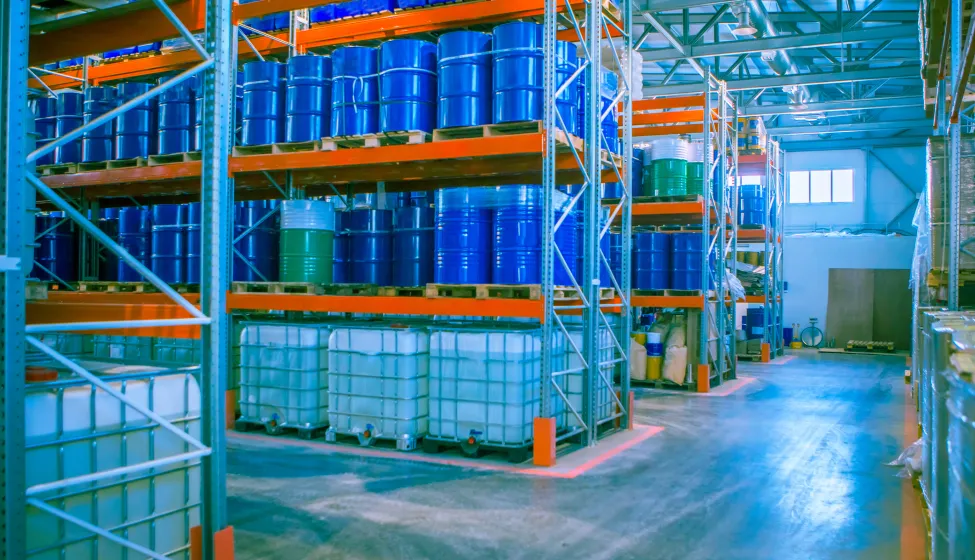 Blue metal barrels. Chemical industry. Metal barrels for chemicals. Warehouse racks. Barrels are kept in stock. Warehouse storage. Logistics in stock.