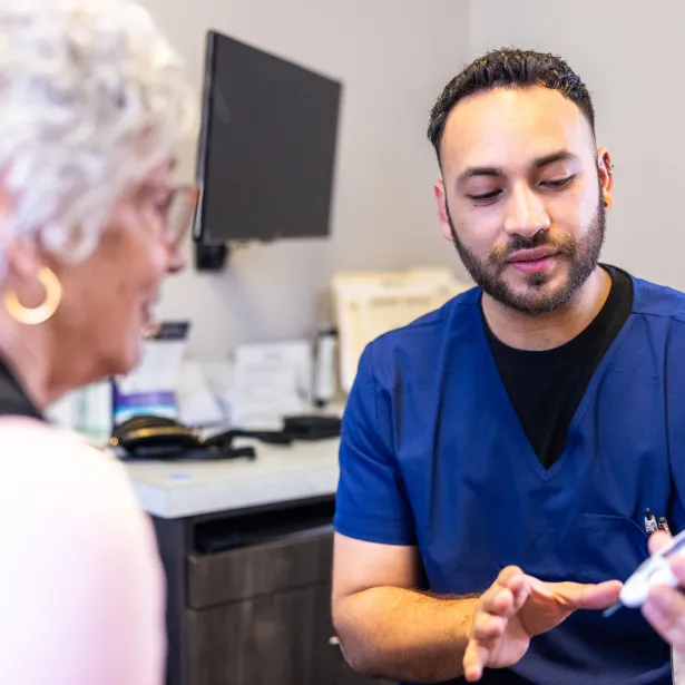 Doctor showing a senior woman how to check her blood sugar
