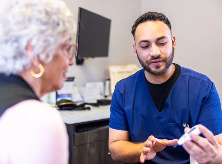 Doctor showing a senior woman how to check her blood sugar