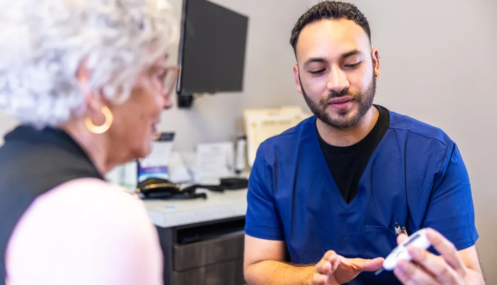 Doctor showing a senior woman how to check her blood sugar
