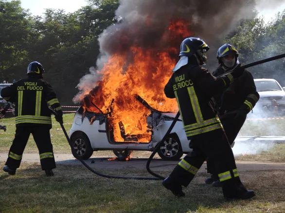 Firefighters extinguishing car on fire