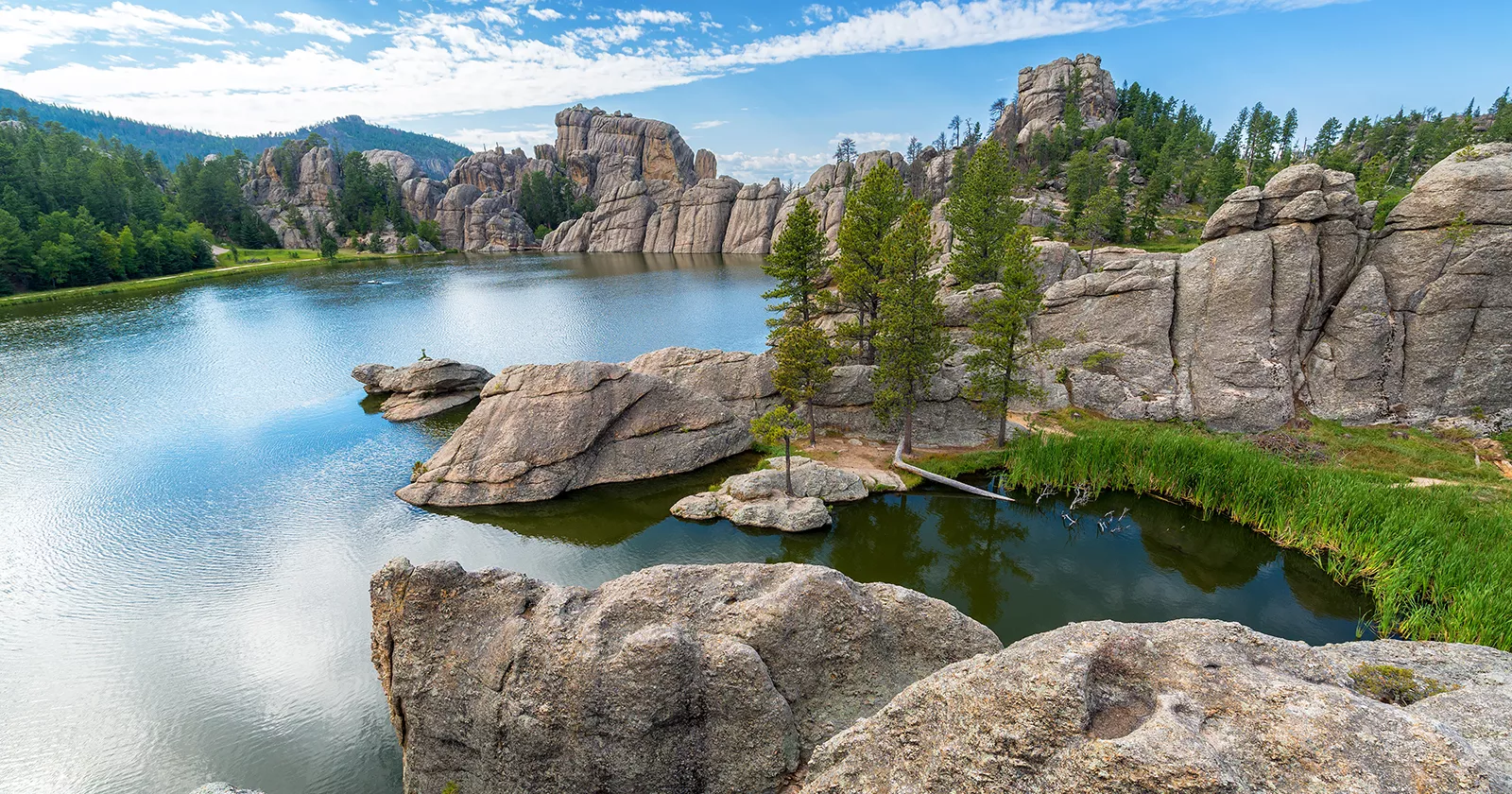 Beautiful natural landscape with boulders, a lake and trees. Exponent helps with environmental permitting.