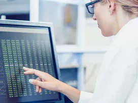 Researcher analyzes a list of numbers on a computer screen. Exponent data scientists provide important data tests and analysis.