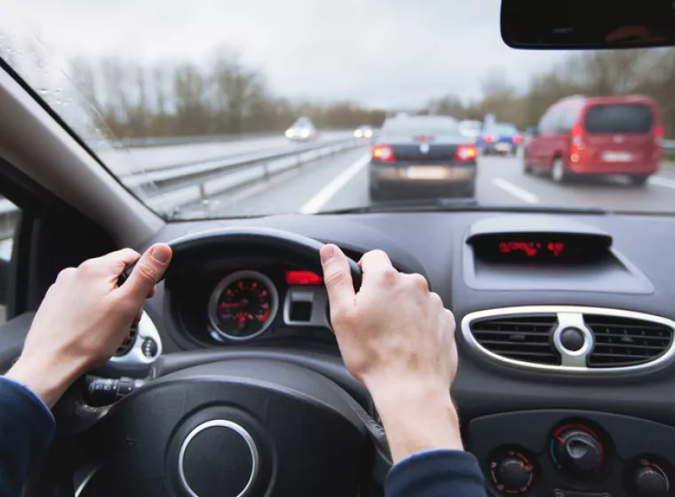 A driver navigating their car on a busy highway. Exponent's vehicle engineers and researchers support innovative driving technologies.