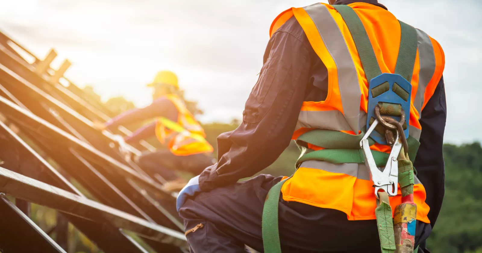 Workers wearing bright construction safety gear. Exponent helps clients identify workplace hazards and mitigate risk of injury.