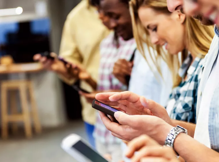 A group of young adults on phones. Exponent provides scientific and engineering expertise for consumer electronics and products.