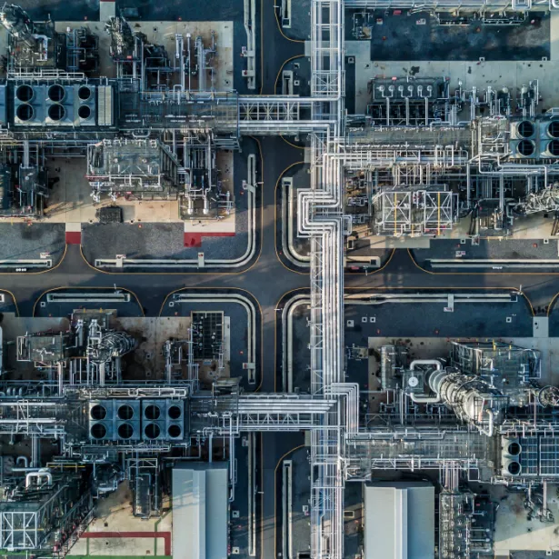 Aerial view of chemical manufacturing plant with smokestacks and piping 