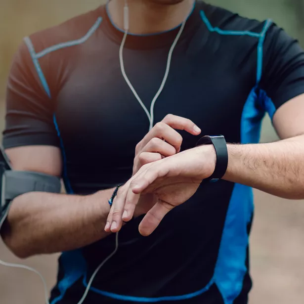 A runner stops to check their smartwatch. Exponent collects real-world evidence and expands data acquisition capabilities to improve healthcare.